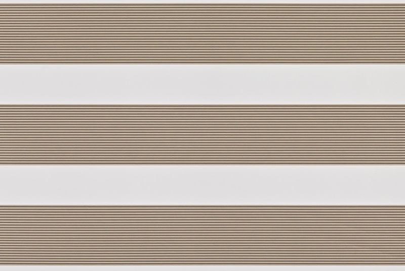 Dual-layer zebra roller blind lowered, alternating beige textured slats and white sheer bands; partially filtering light across a neutral interior wall, producing soft, evenly diffused daylight.