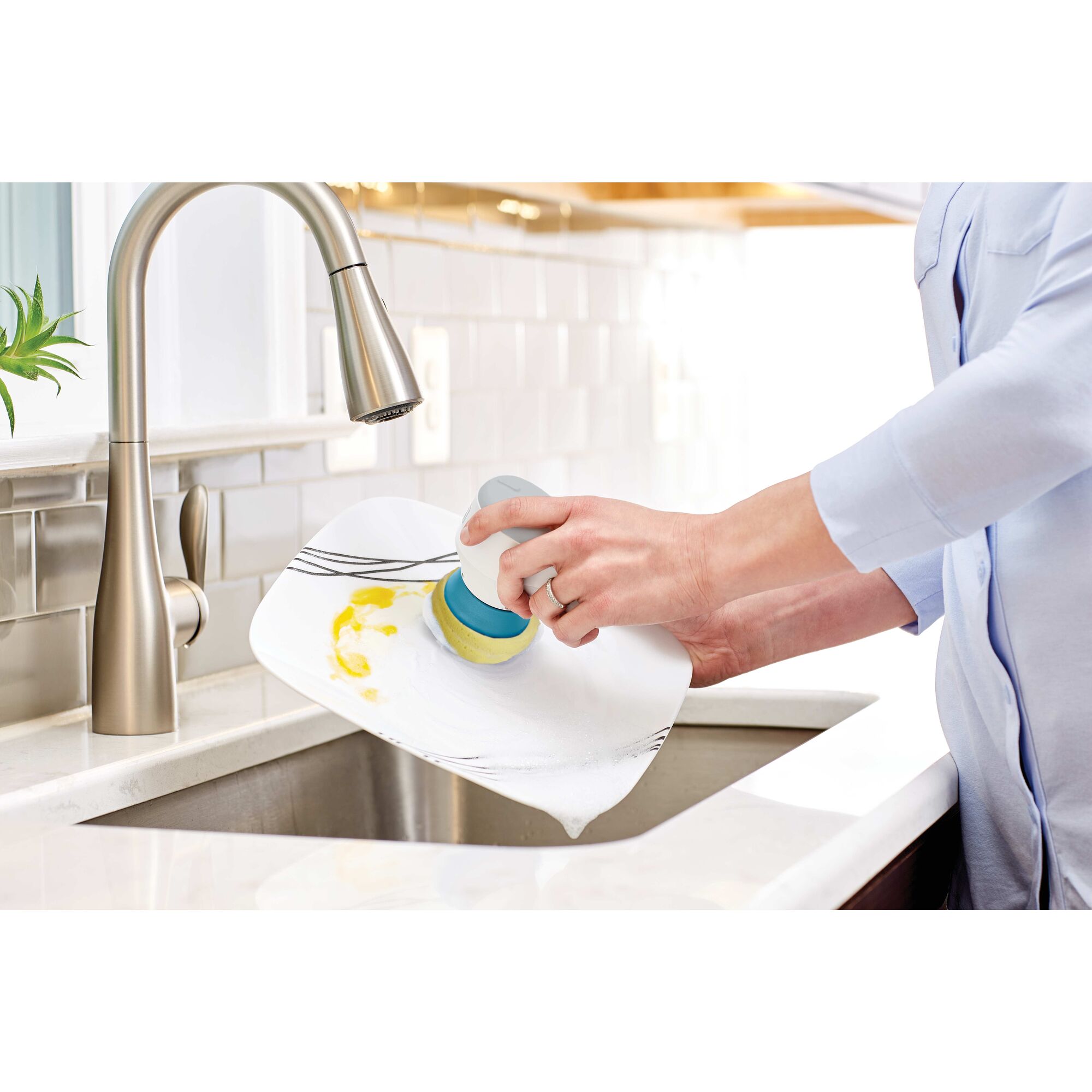 Grimebuster Powered Scrubber being used for washing dishes.