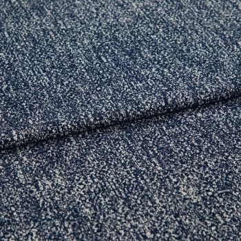 Folded speckled navy woven fabric close-up showing dense white fleck pattern; fabric lies layered and slightly overlapping, highlighting textured weave under soft studio lighting on a neutral background.