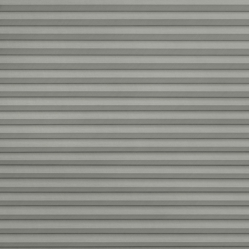 Gray horizontal pleated blinds, fully closed with overlapping slats, blocking light; occupying a window in a softly lit room, creating a uniform, layered shadow pattern.