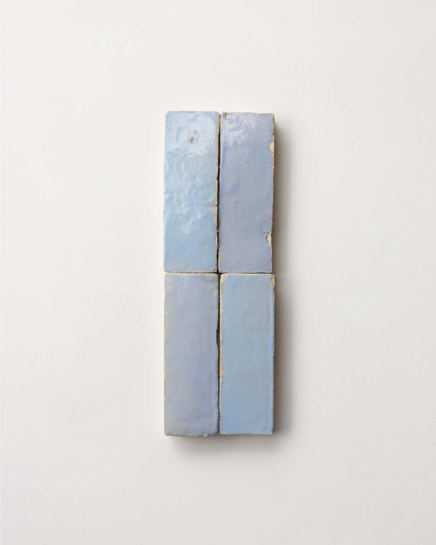 4 blue ceramic tiles on a white surface.