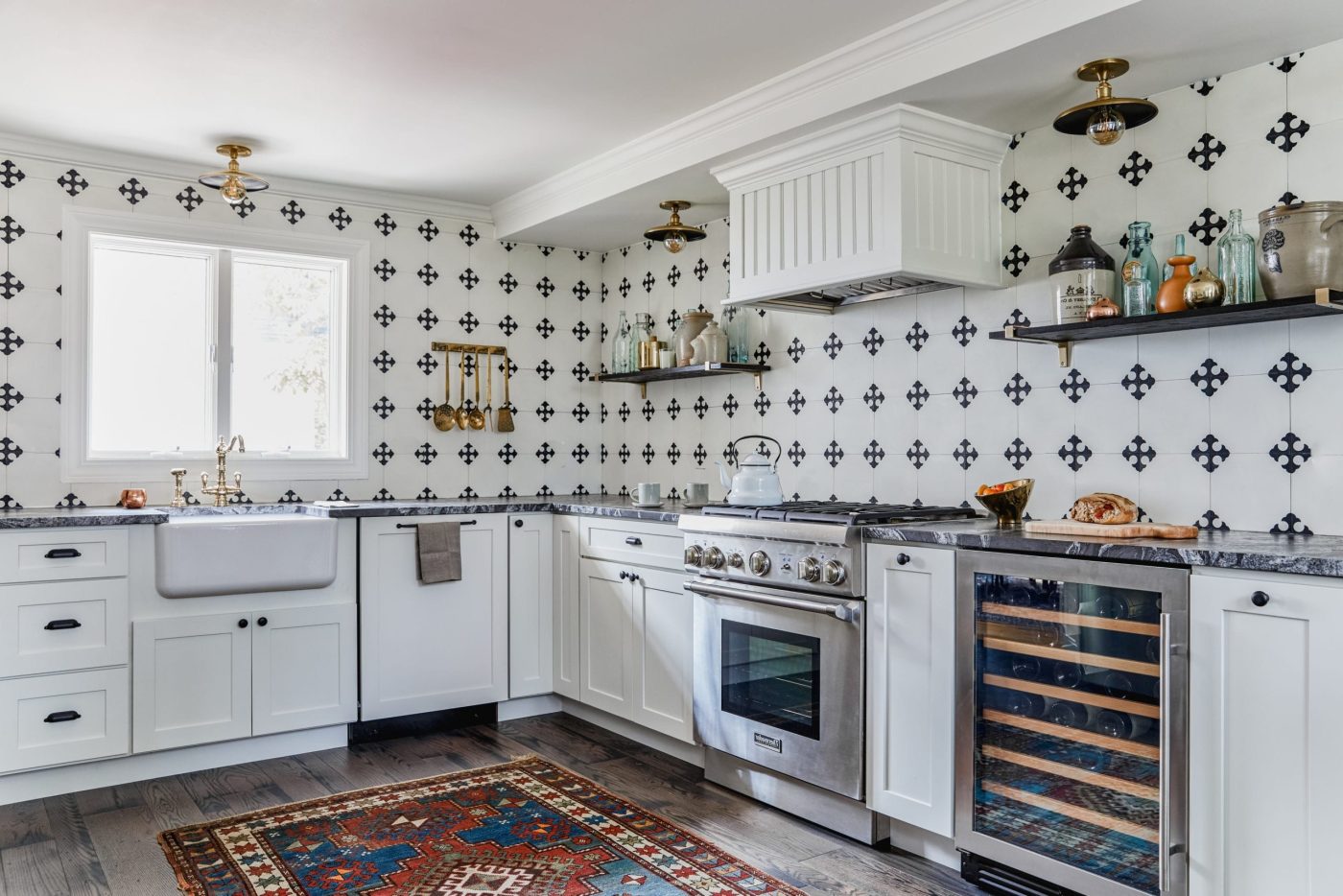 a kitchen with black and white cross patterned tiles and a rug.