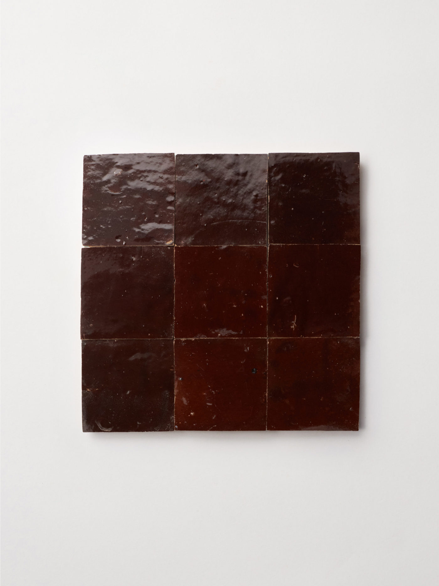 9 square square brown tiles on a white surface.