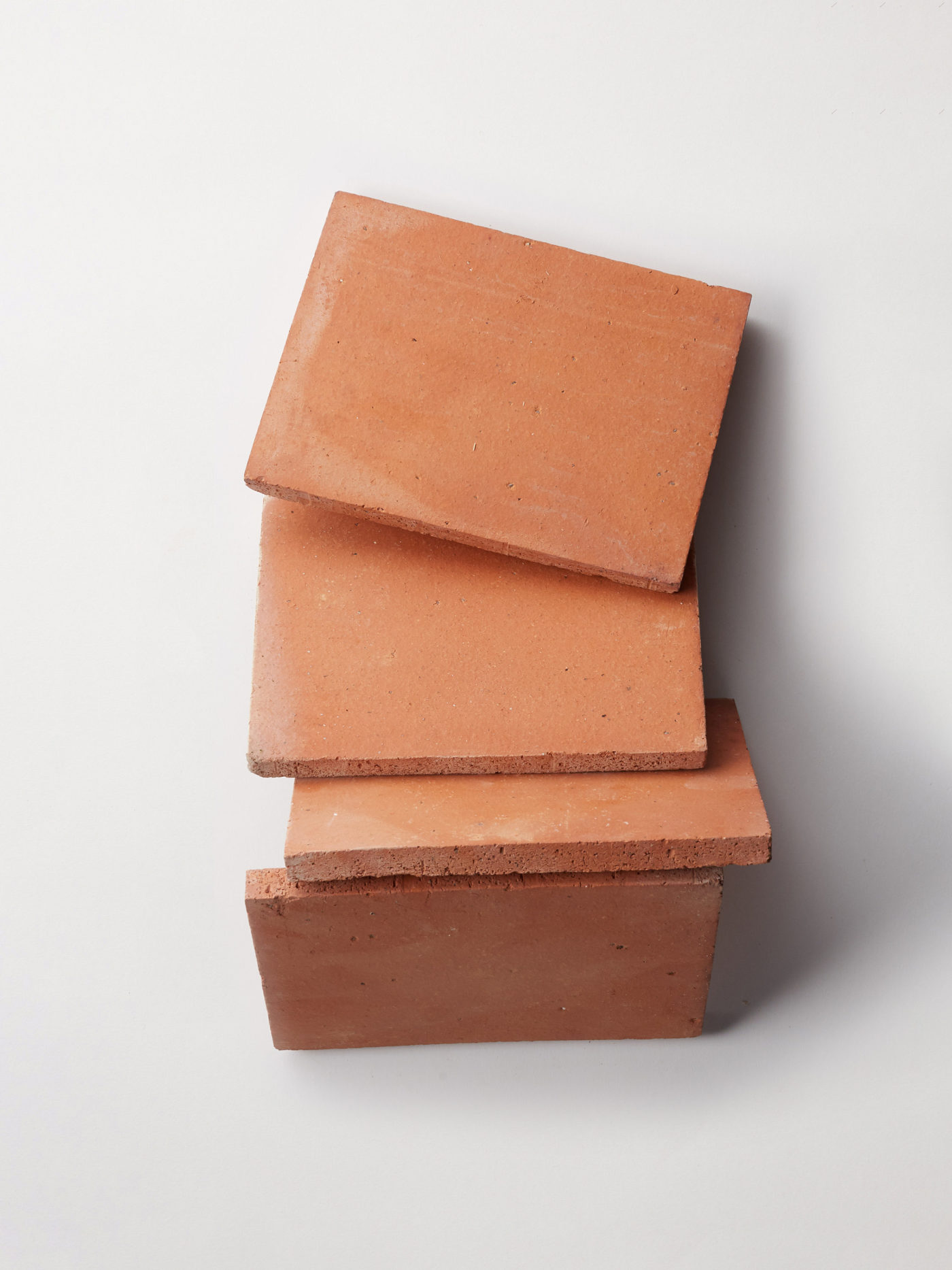 a stack of red terracotta tiles on a white background.