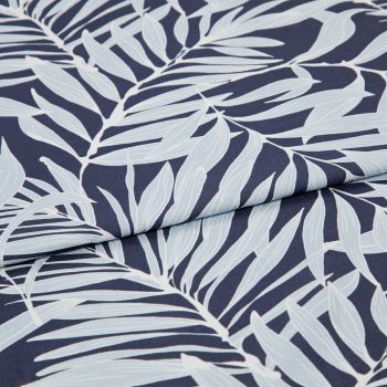 Navy textile printed with pale-blue palm-leaf motif, folded across the center producing an overlapping seam; close-up studio view highlighting fabric texture and even, soft lighting.