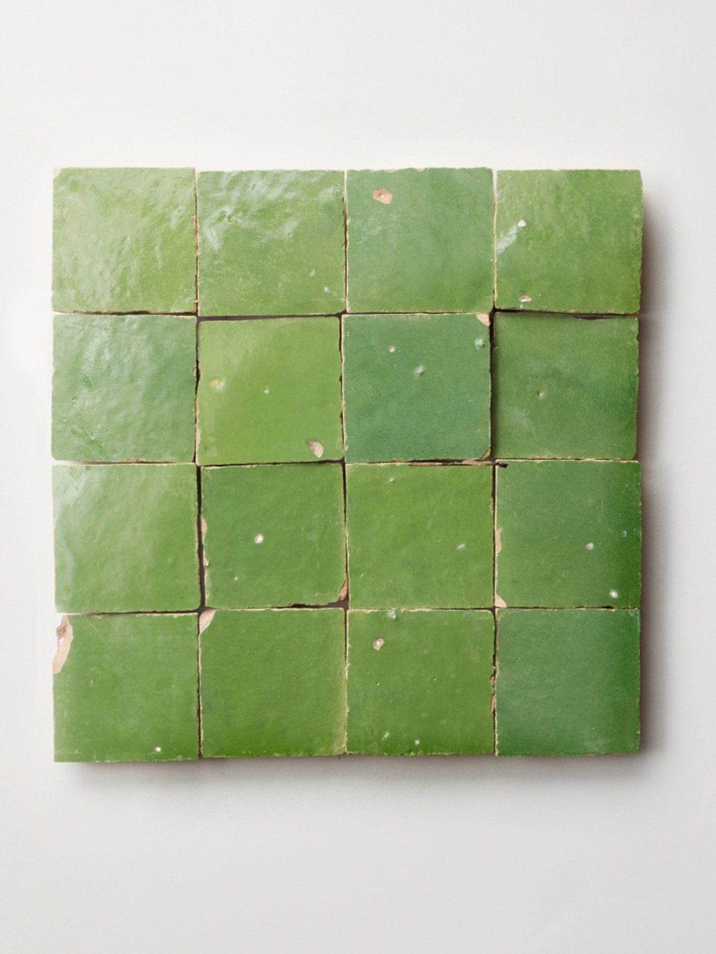 pieces of green tile on a white surface.