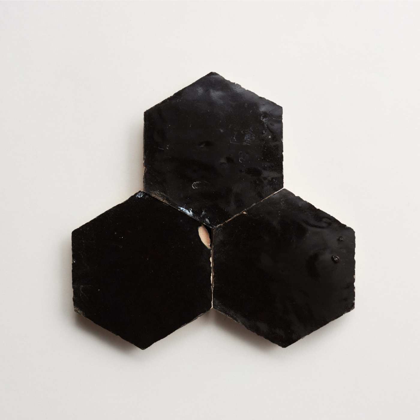 three black hexagon tiles on a white surface.