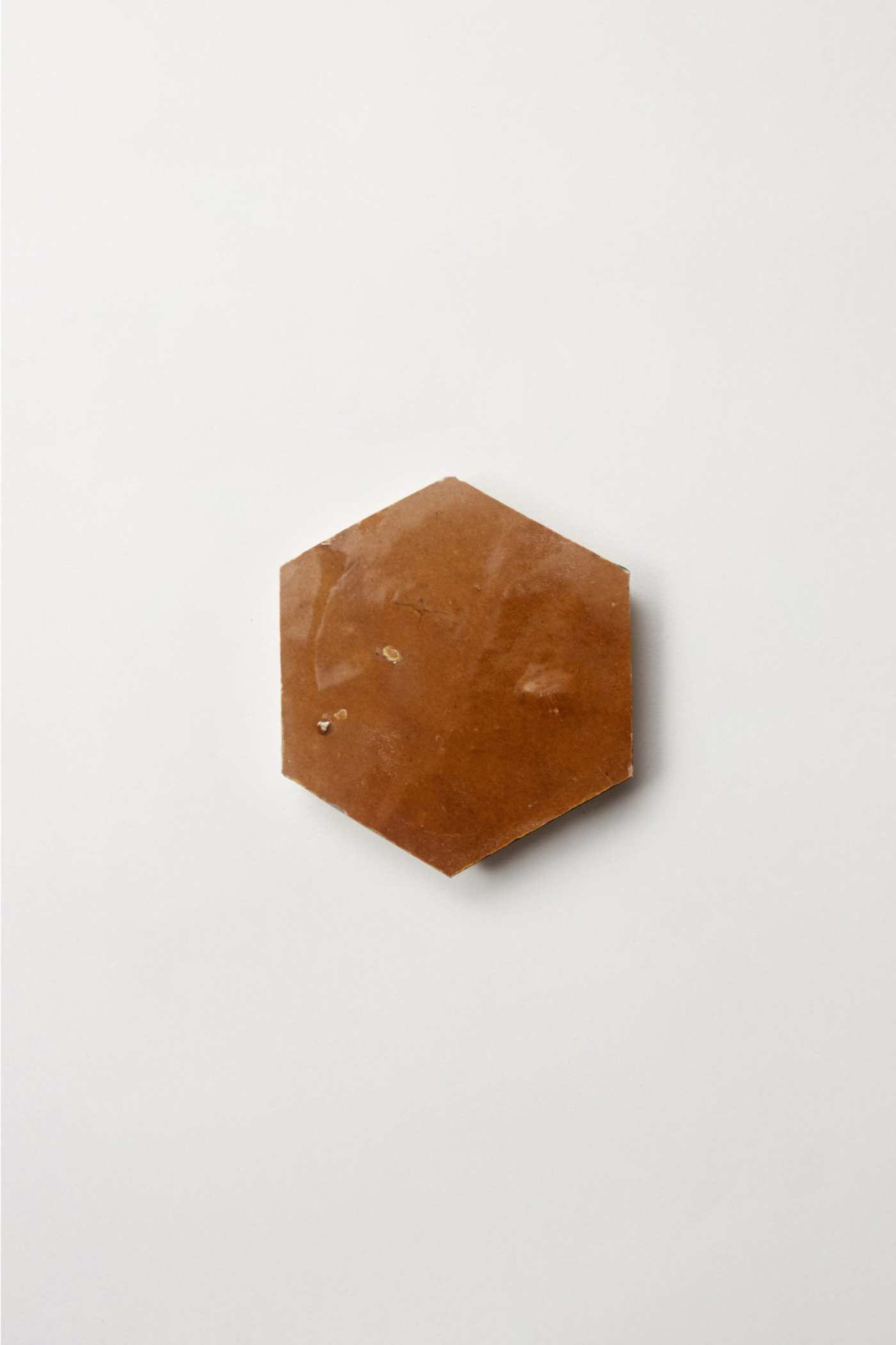 a brown hexagonal tile on a white surface.