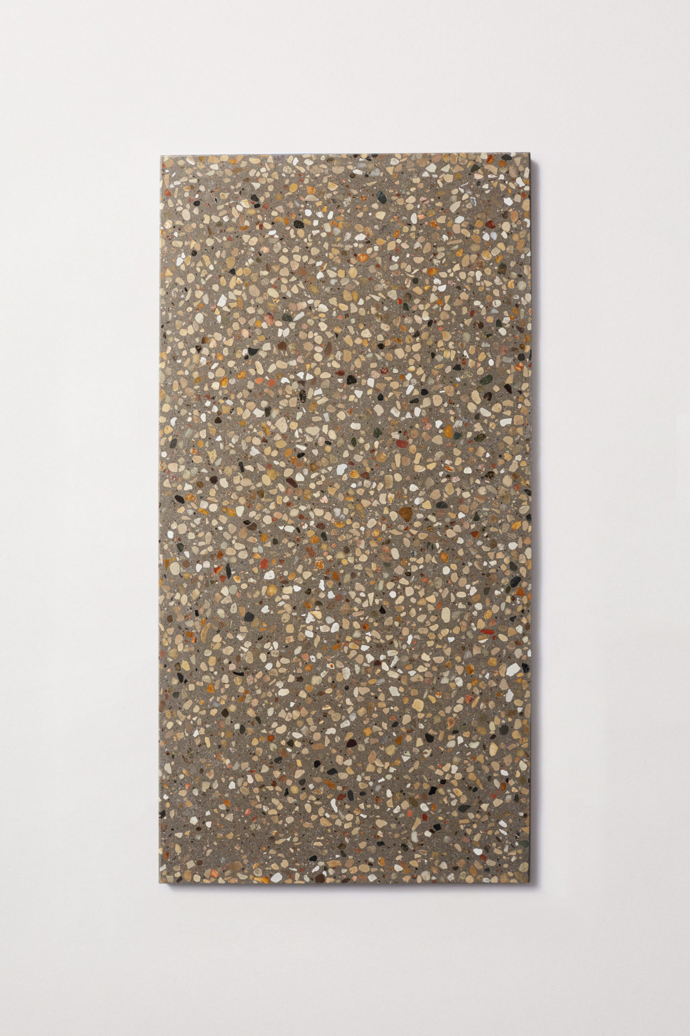 a rectangular terrazzo tile on a white surface.