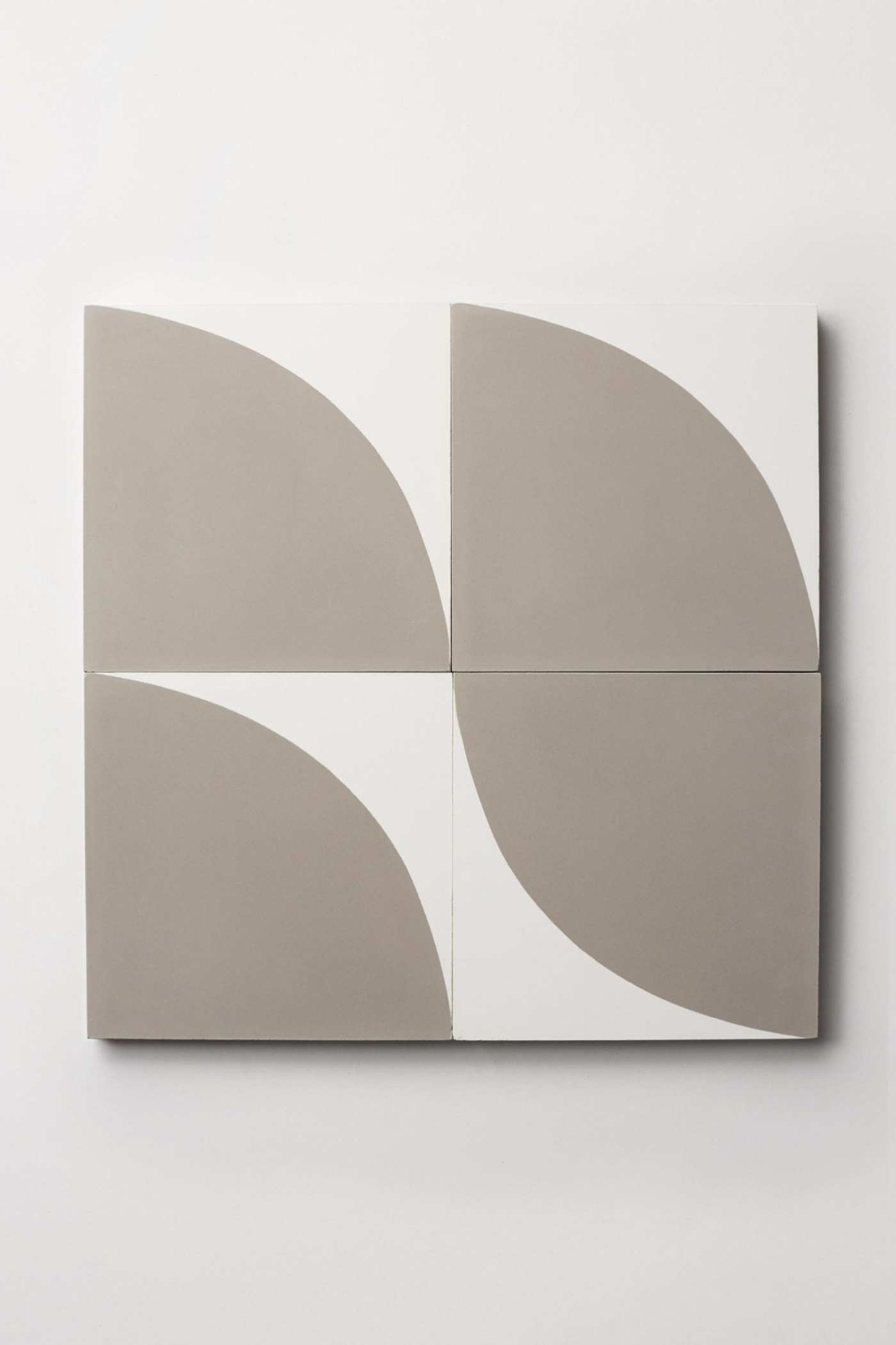 four white and grey tiles on a white surface.