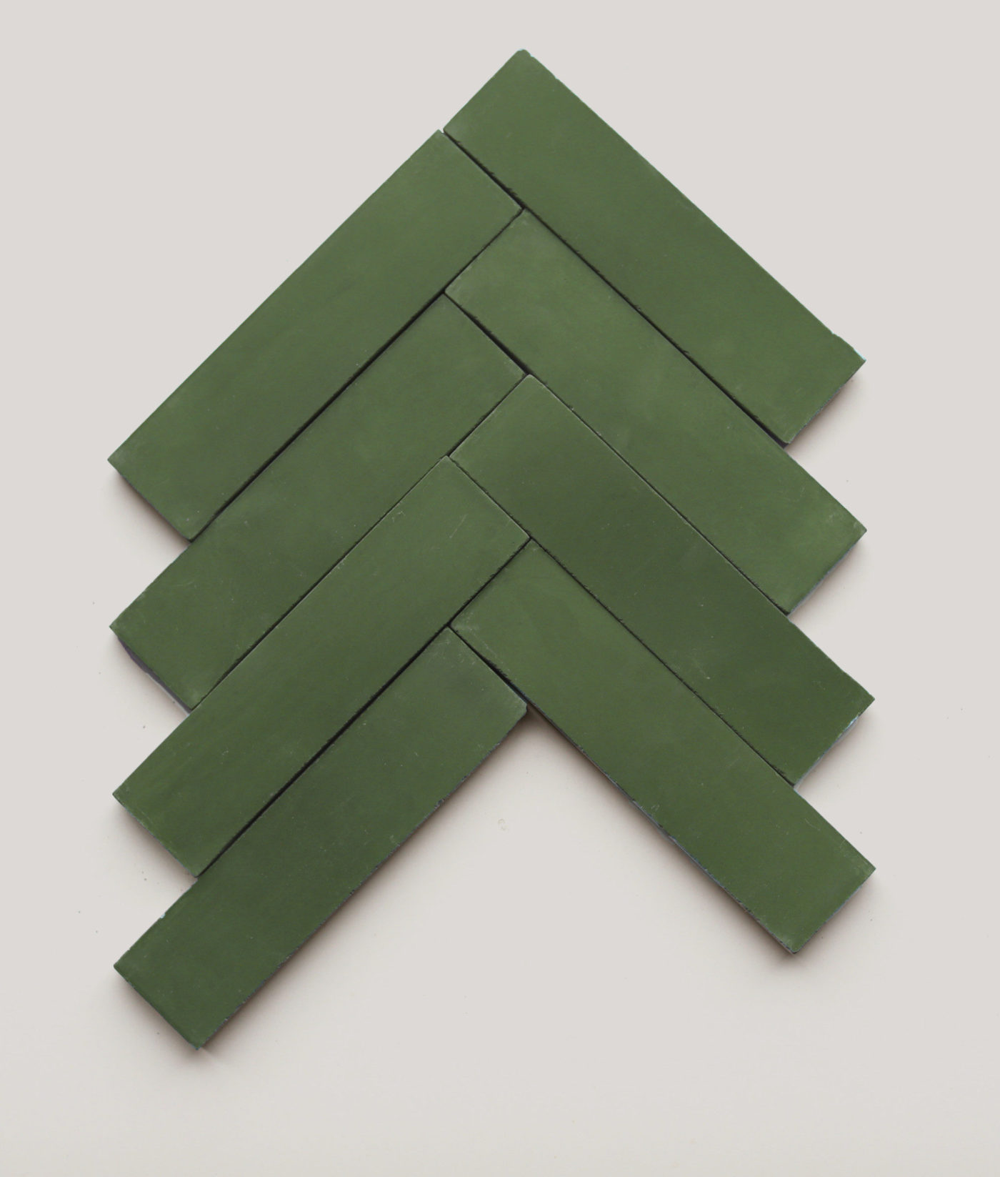 a set of green tiles in a herringbone pattern on a white background.