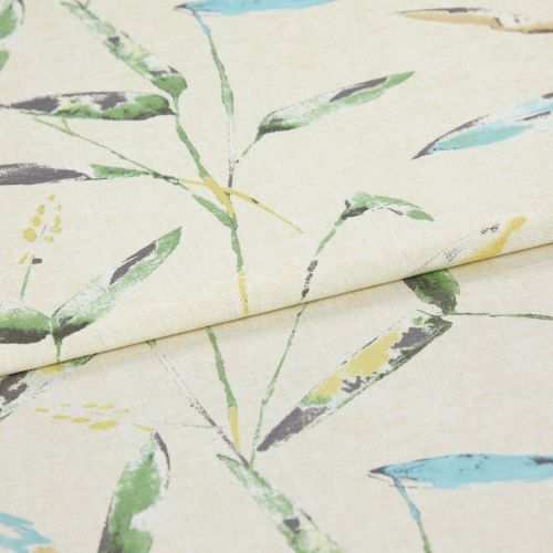 Linen-like curtain fabric, folded with a horizontal crease, printed with watercolor-style green, blue and yellow leaves; close-up studio shot on neutral beige background under soft light.