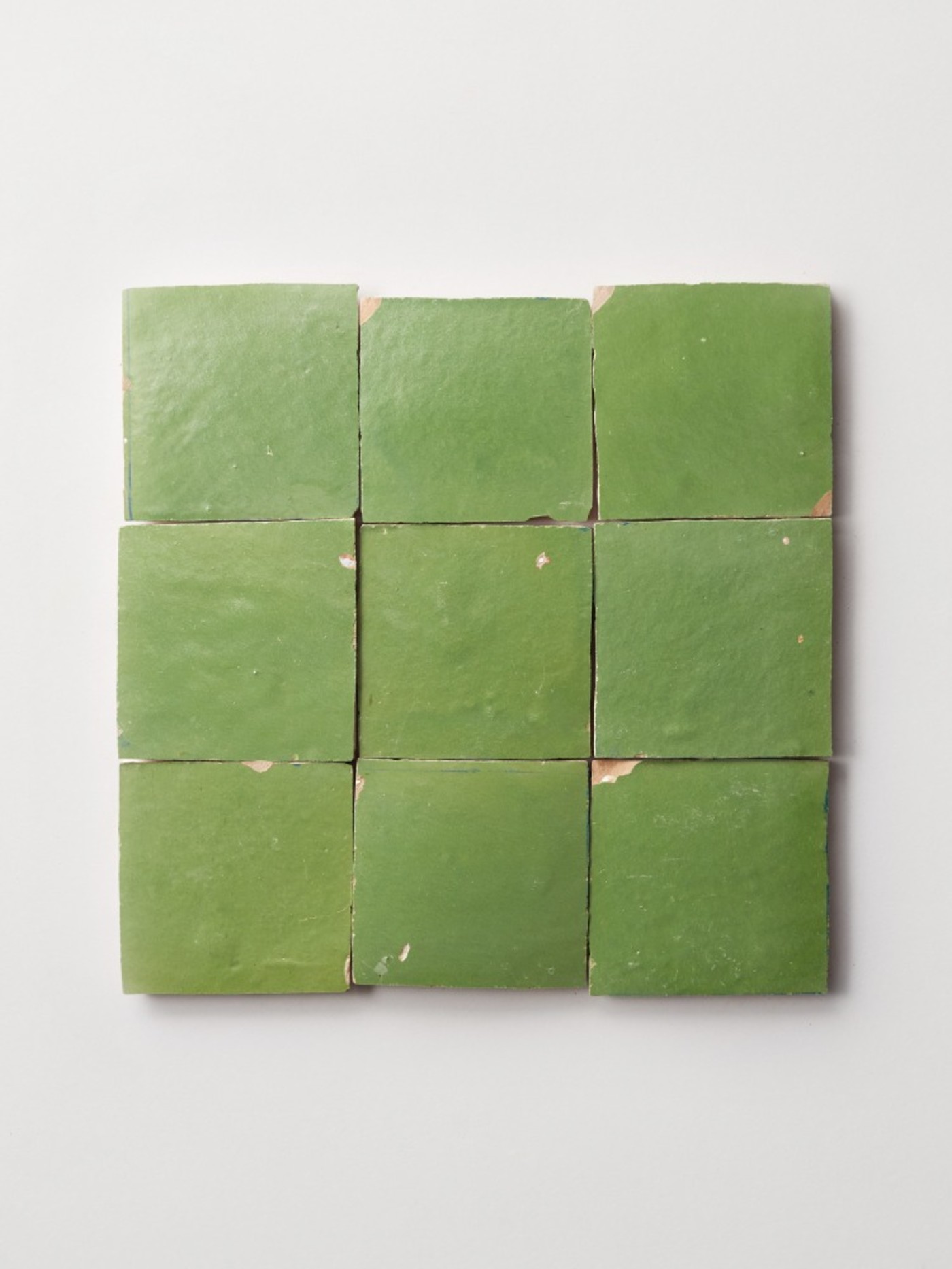 a set of green tiles on a white surface.