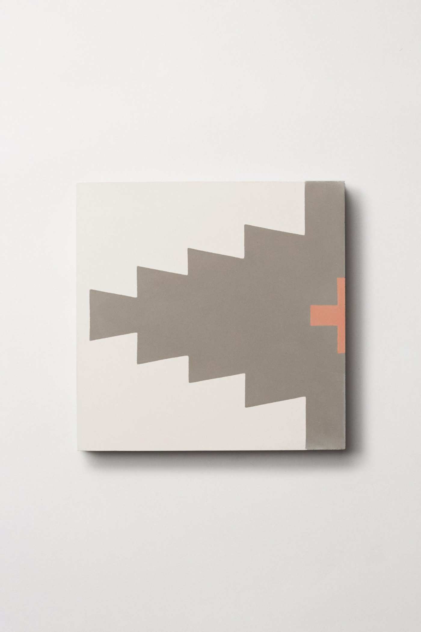 a white, grey and red tile with a triangular pattern on it.