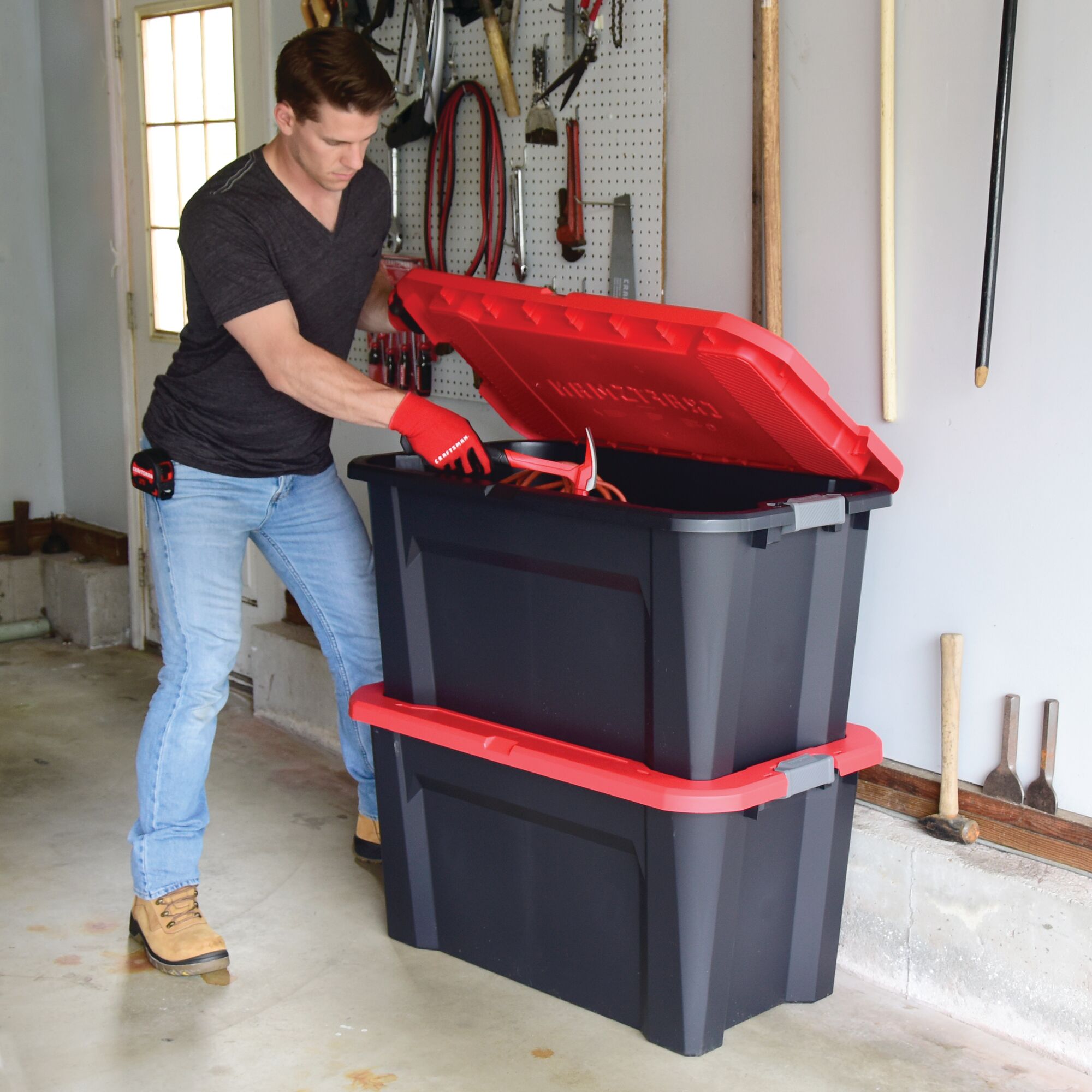 40 Gallon latching tote being used by a person to store tools.