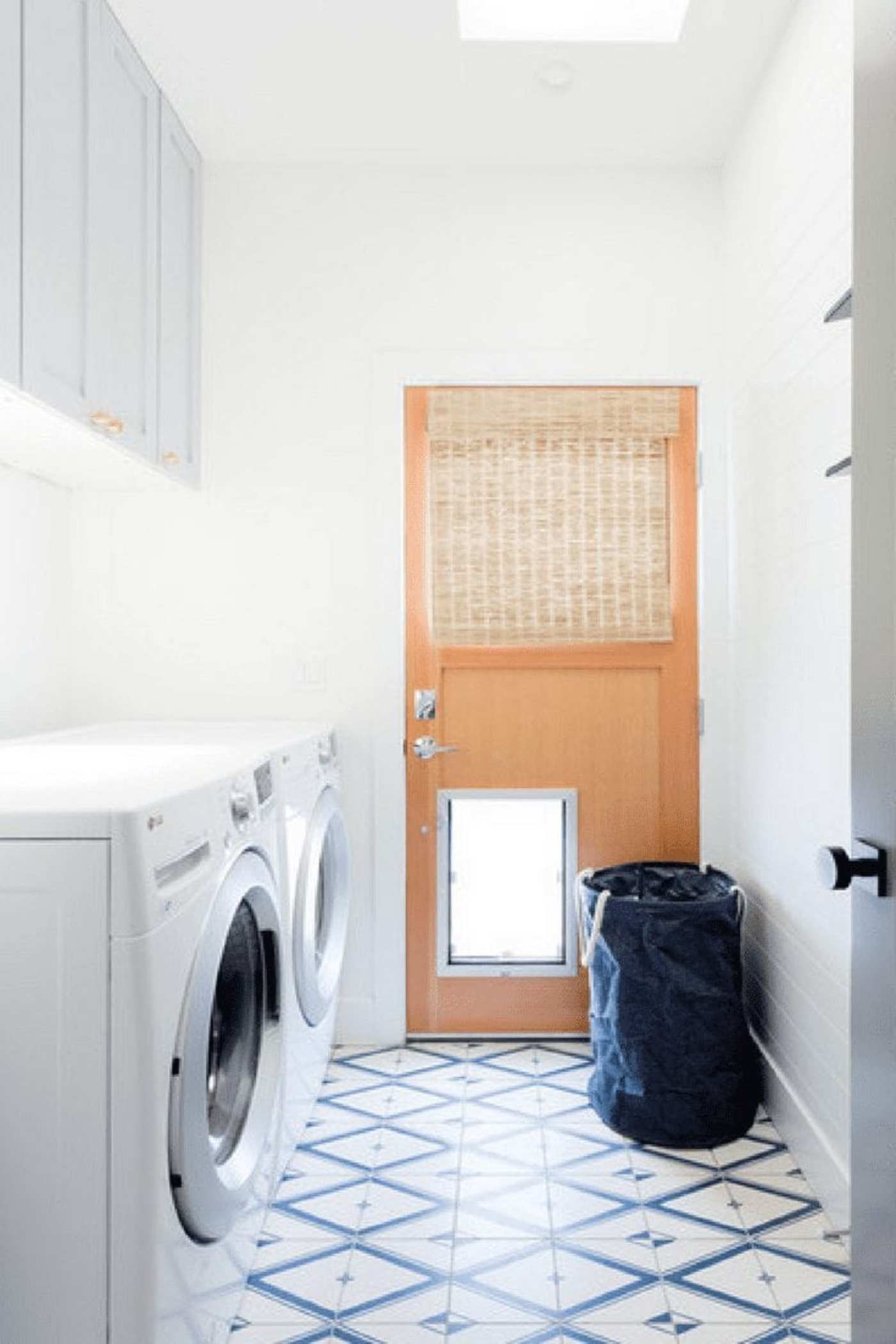 a laundry room with a washer, dryer, and white and blue tiled floor.