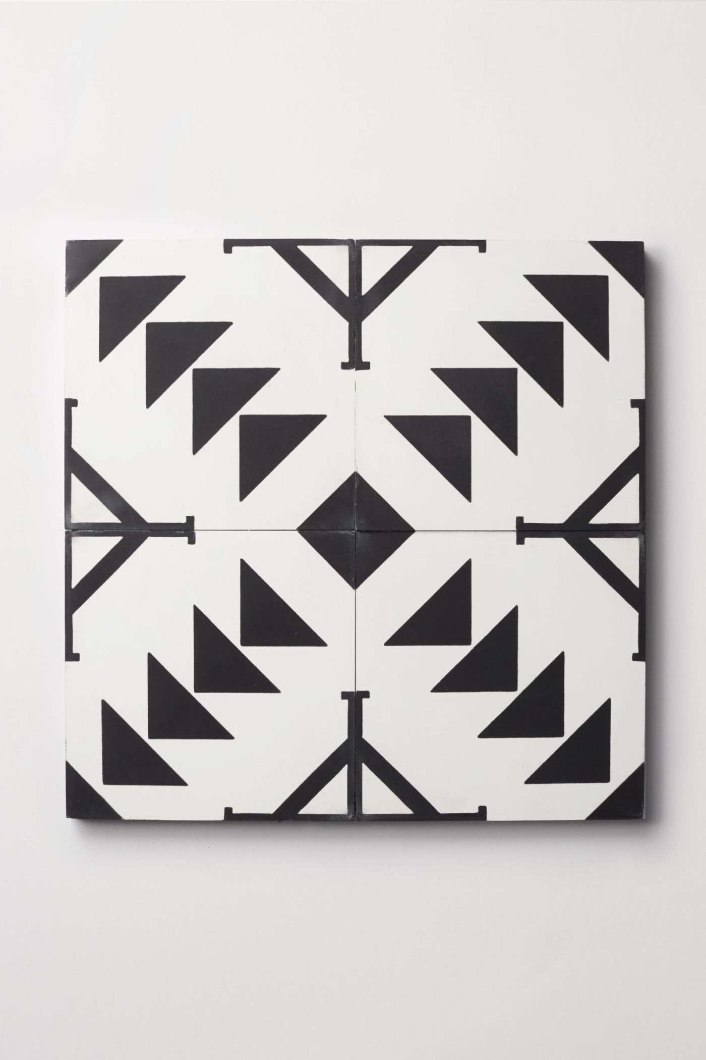 four black and white tiles with geometric designs.