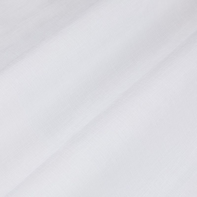 Sheer white curtain panel with fine woven texture, draping in soft diagonal folds, gently filtering diffuse light against a bright, neutral interior—close-up view.