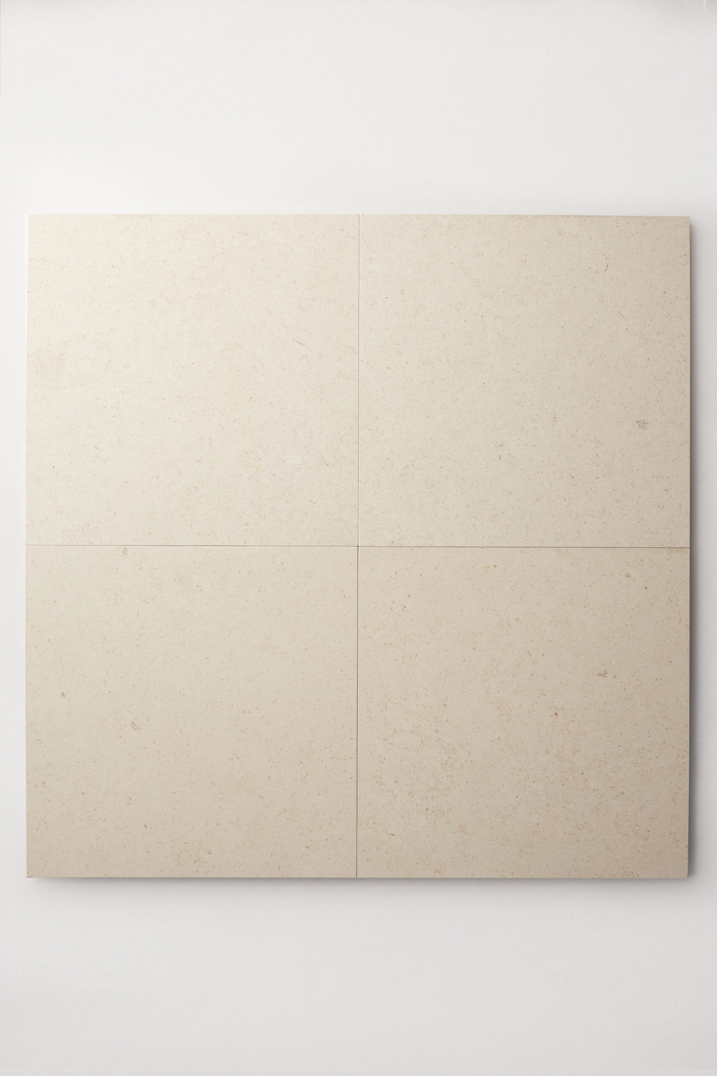 four square limestone tiles on a white surface.