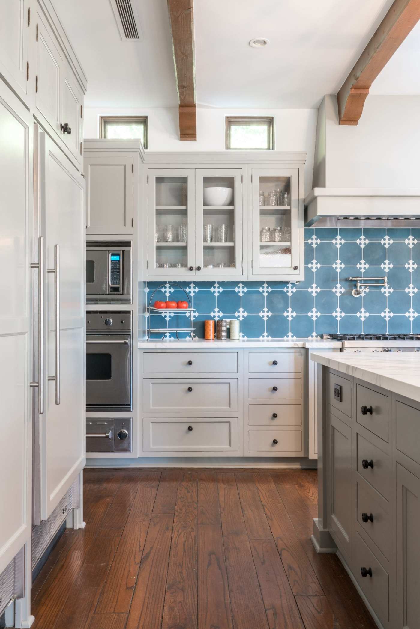 a kitchen with a blue and white patterned tile wall.