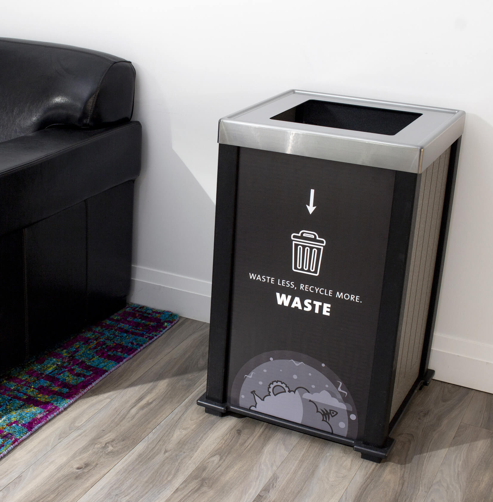 black waste bin with a stainless steel lid sitting beside a leather chair in an office