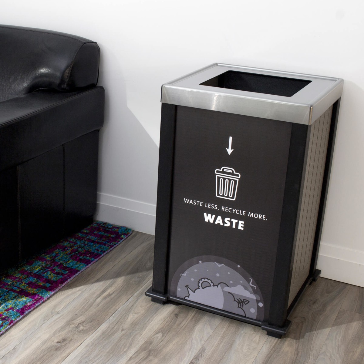 black waste bin with a stainless steel lid sitting beside a leather chair in an office