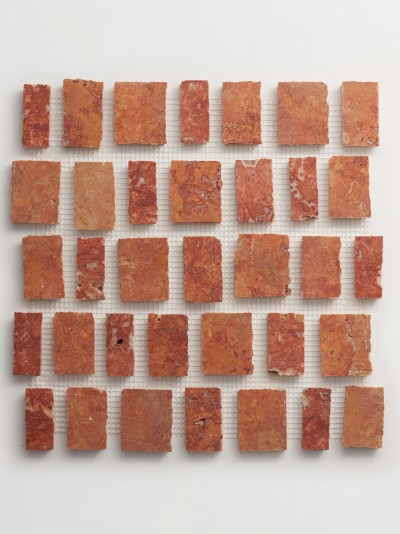 a mosaic of red and brown squares on a white surface.