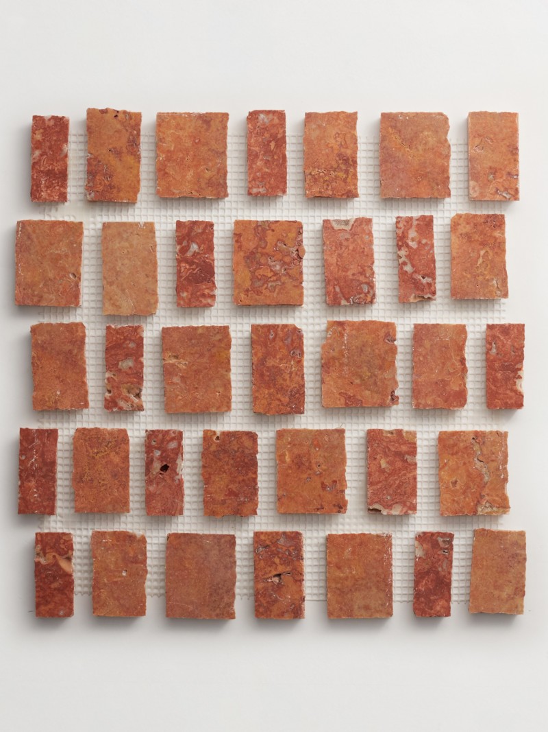 a mosaic of red and brown squares on a white surface.