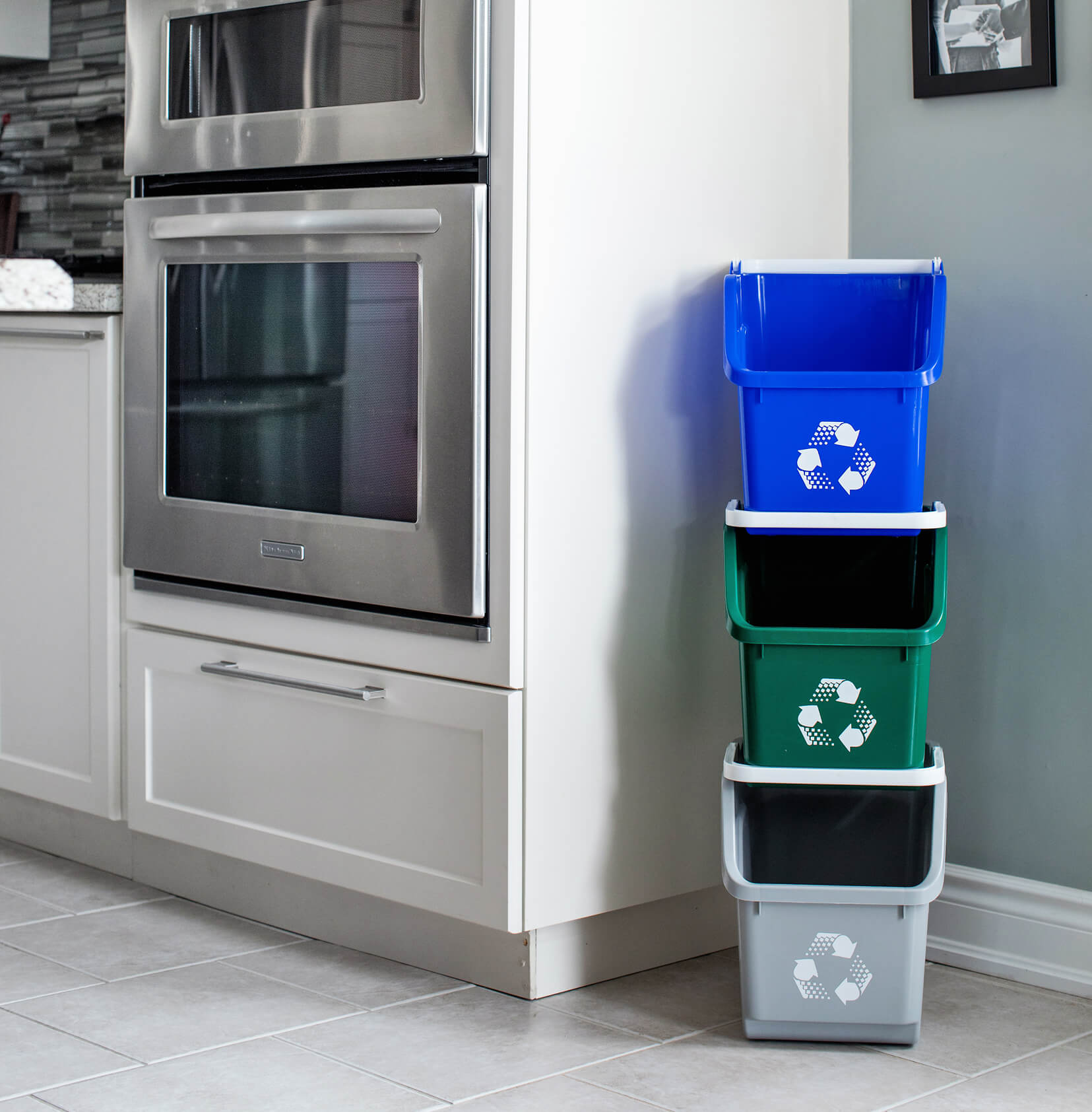 color-coded plastic stacked recycling bins in a modern kitchen