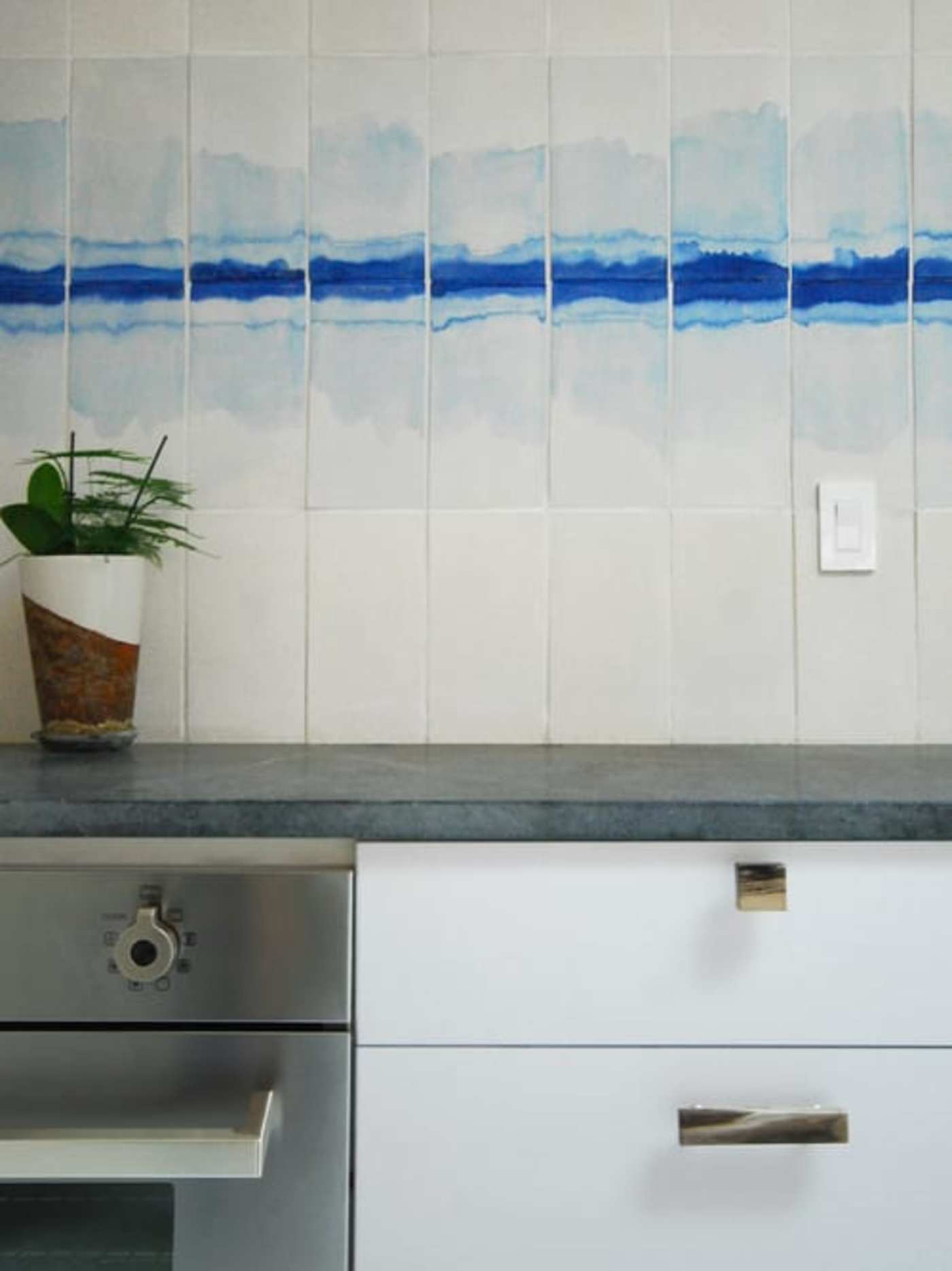 a kitchen with a blue and white tile backsplash.