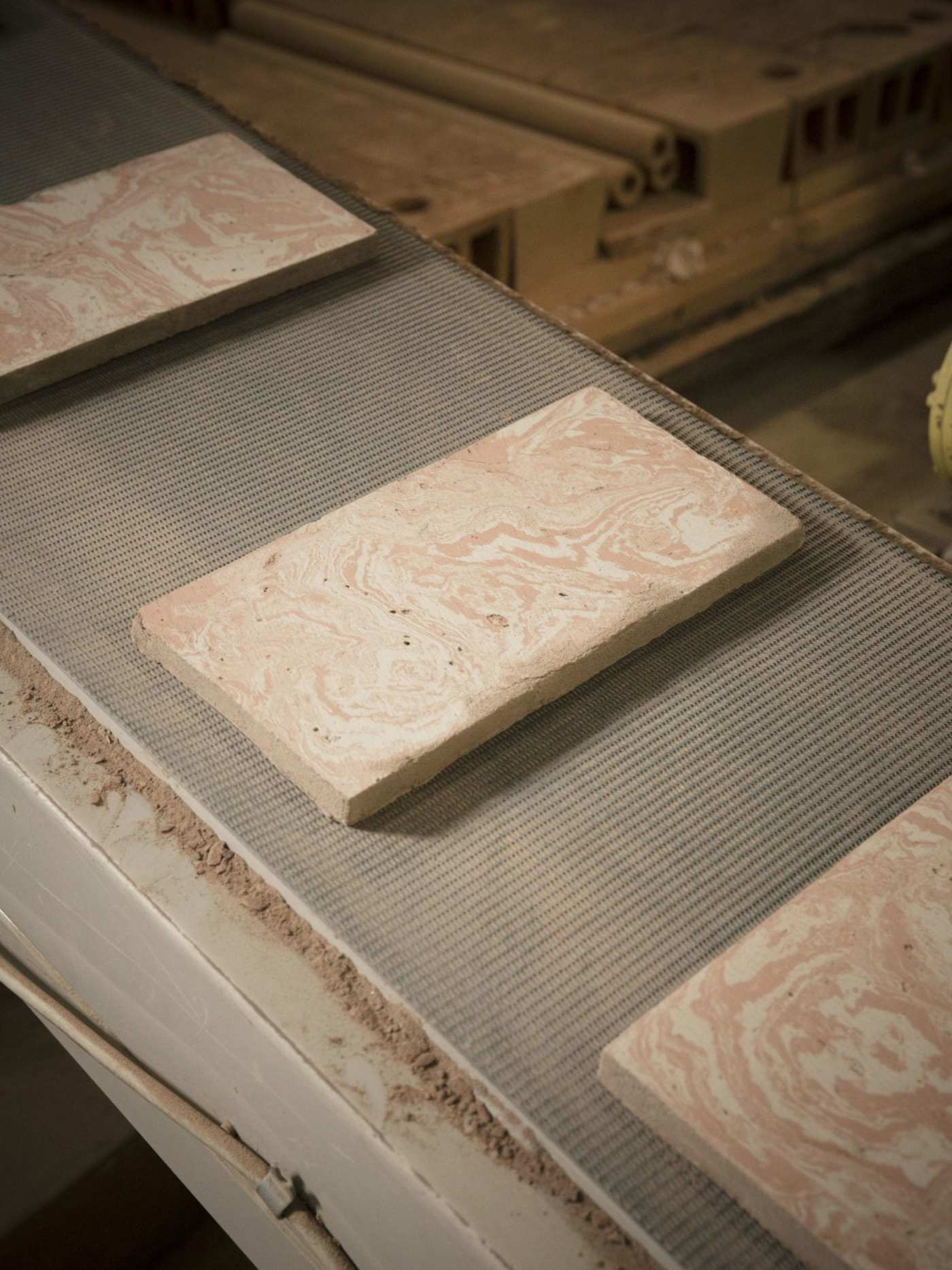 red white white rectangle tiles on a conveyor belt in a factory.