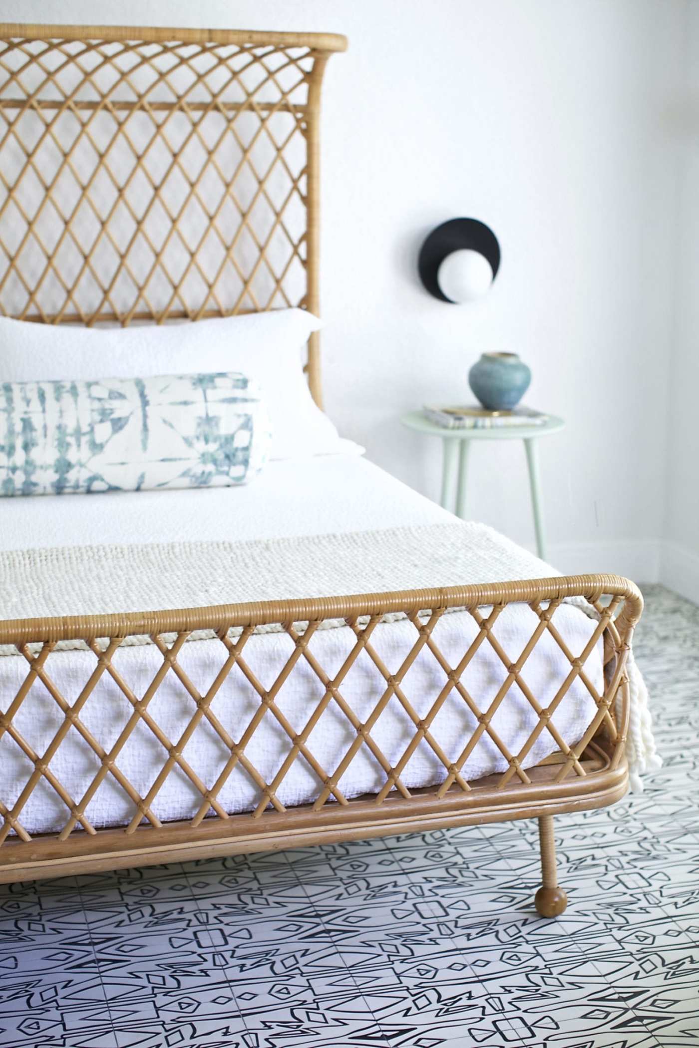 a bed with a rattan headboard in a bedroom.