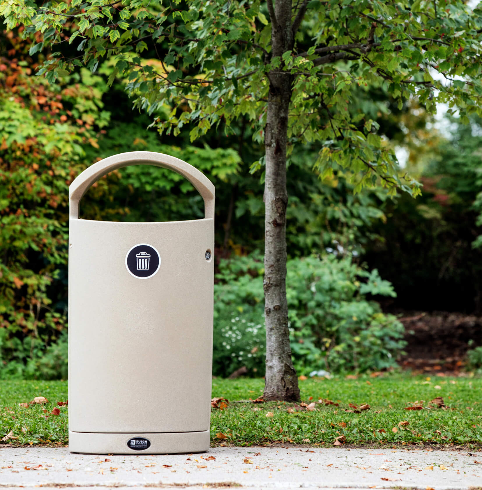 beige waste container with canopy lid outside along path in municipal park