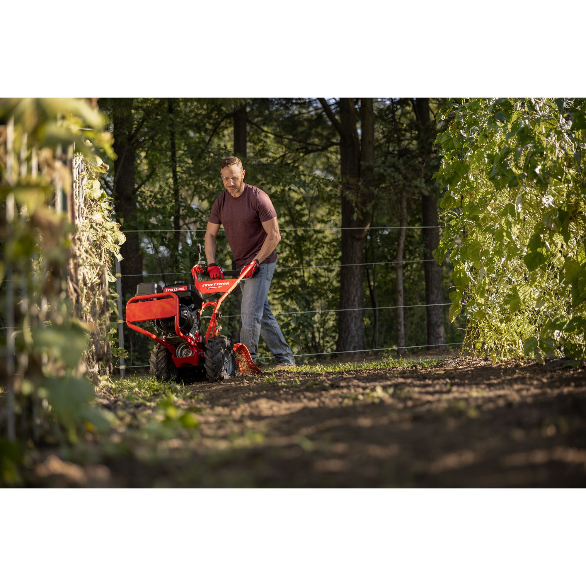 CRAFTSMAN 16-in. 208cc Gas Rear Tine Tiller tilling garden area with trees in background