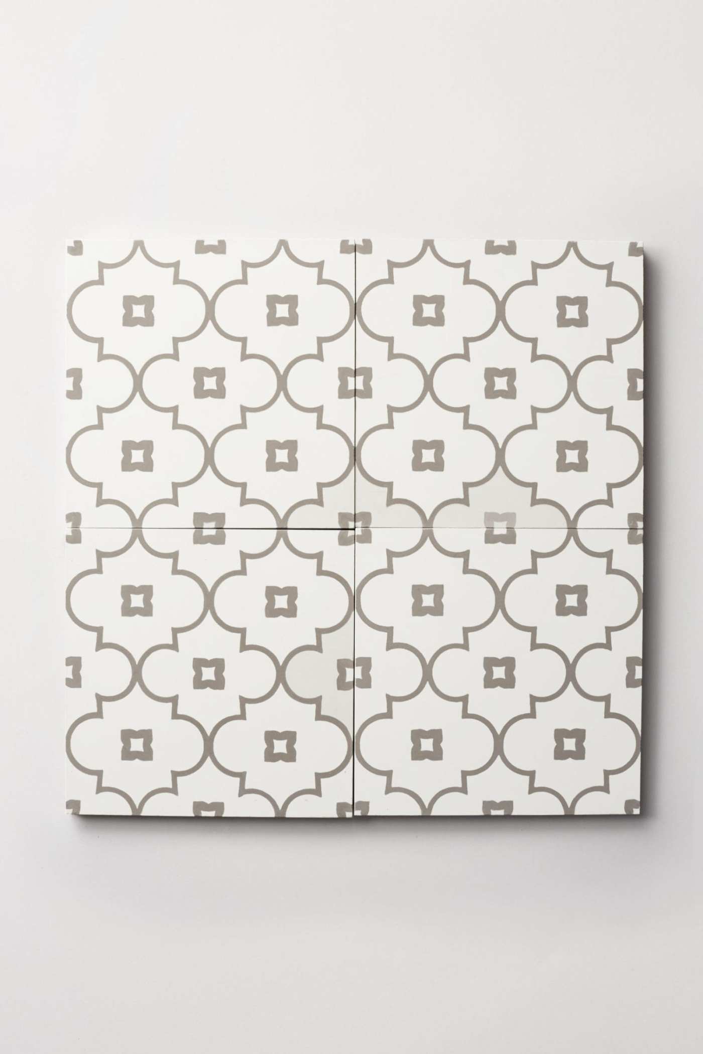 four white and grey tiles with geometric patterns.