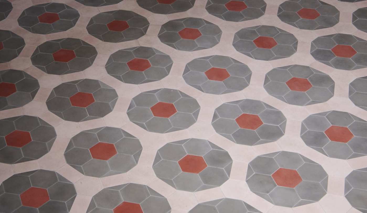 an image of a tile floor with grey and red circles.