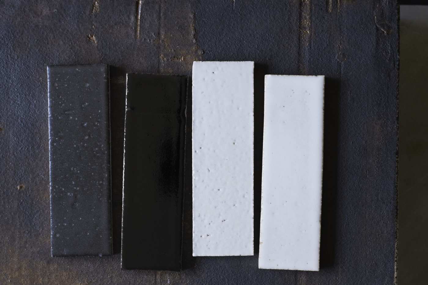 four black and white tiles on a wooden surface.