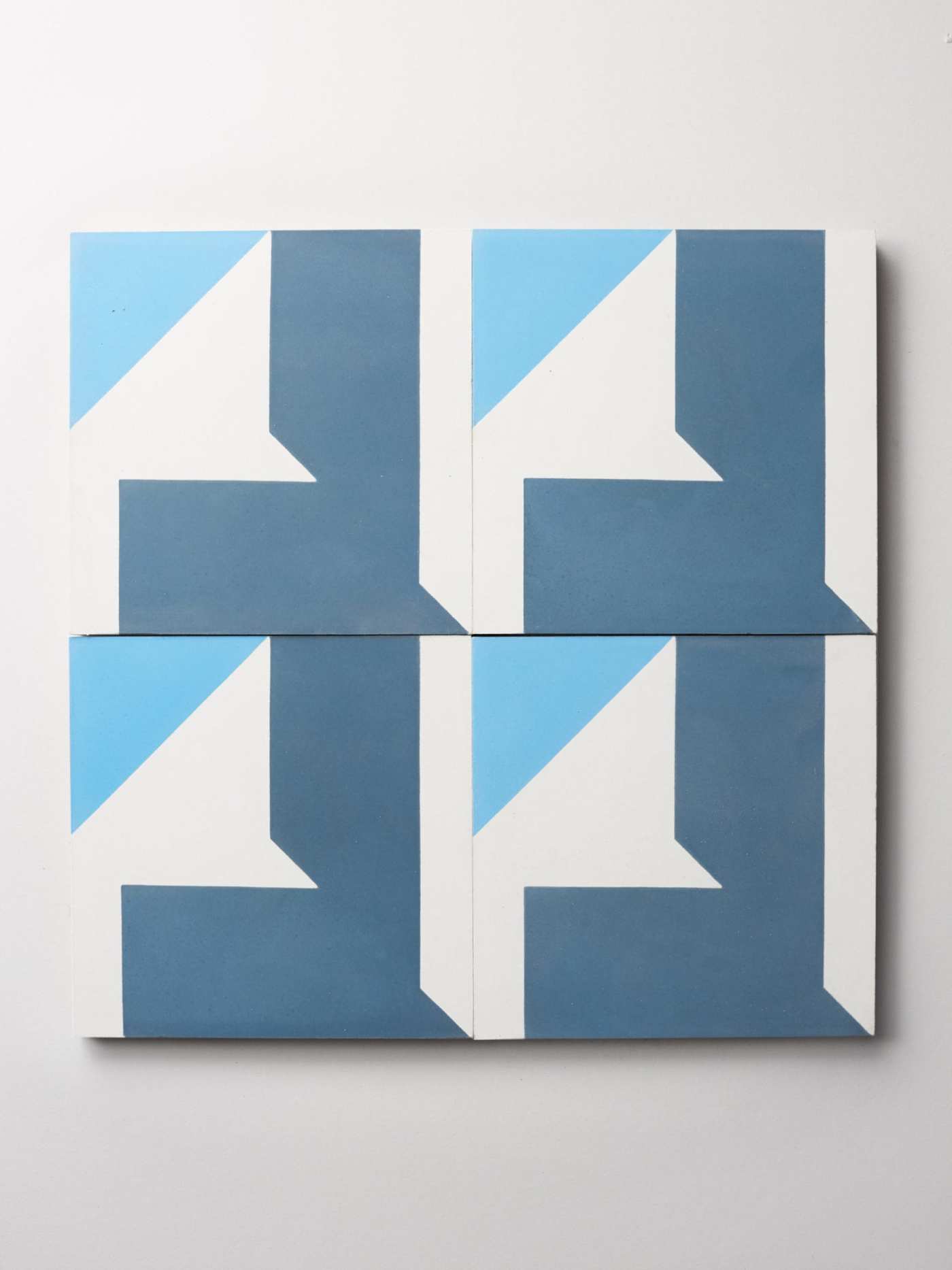four blue and white tiles on a white background.