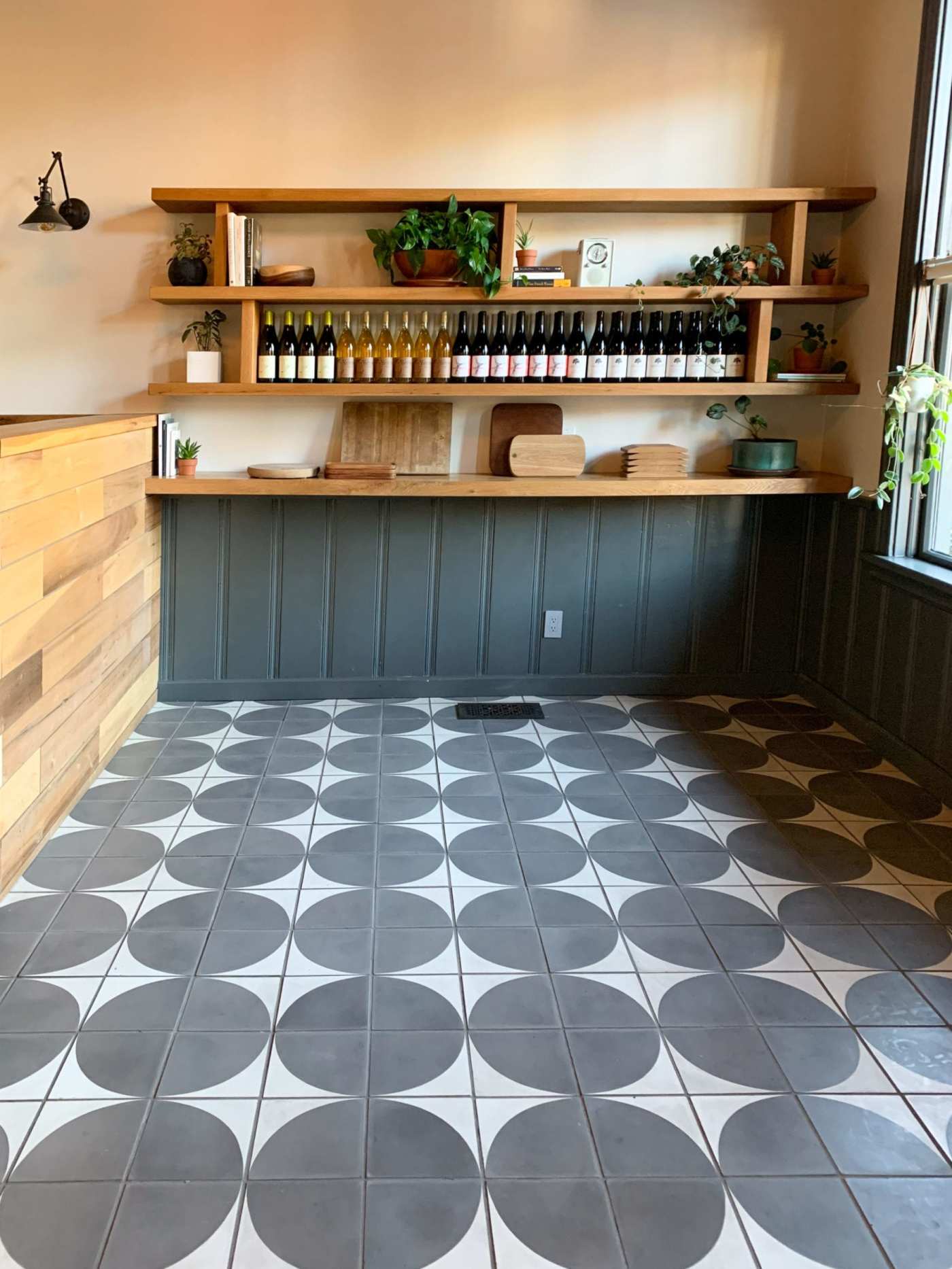 a kitchen with a tiled floor and wooden shelves.