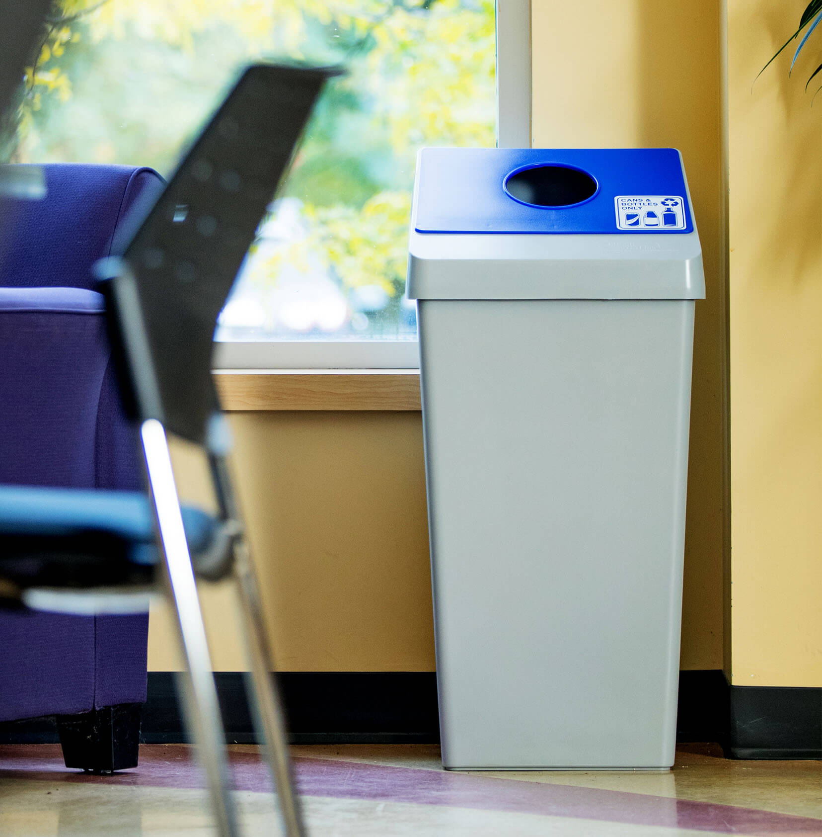cans and bottles recycling bin with a blue restrictive opening lid in a corporate office break room