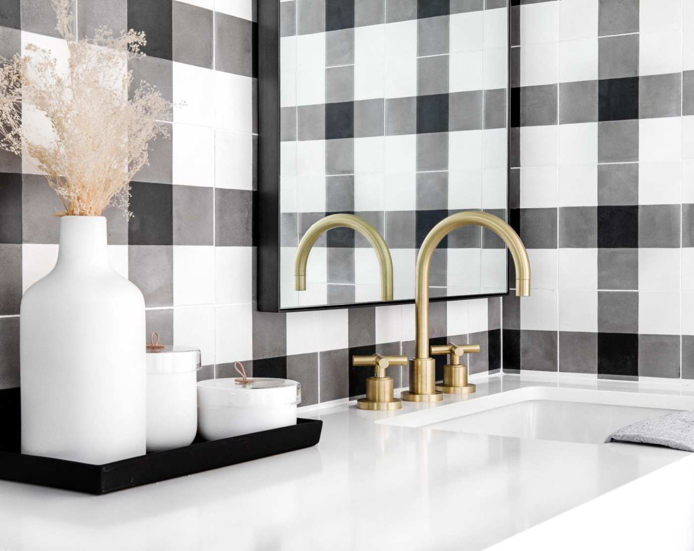 a bathroom with a black and white checkered backsplash.