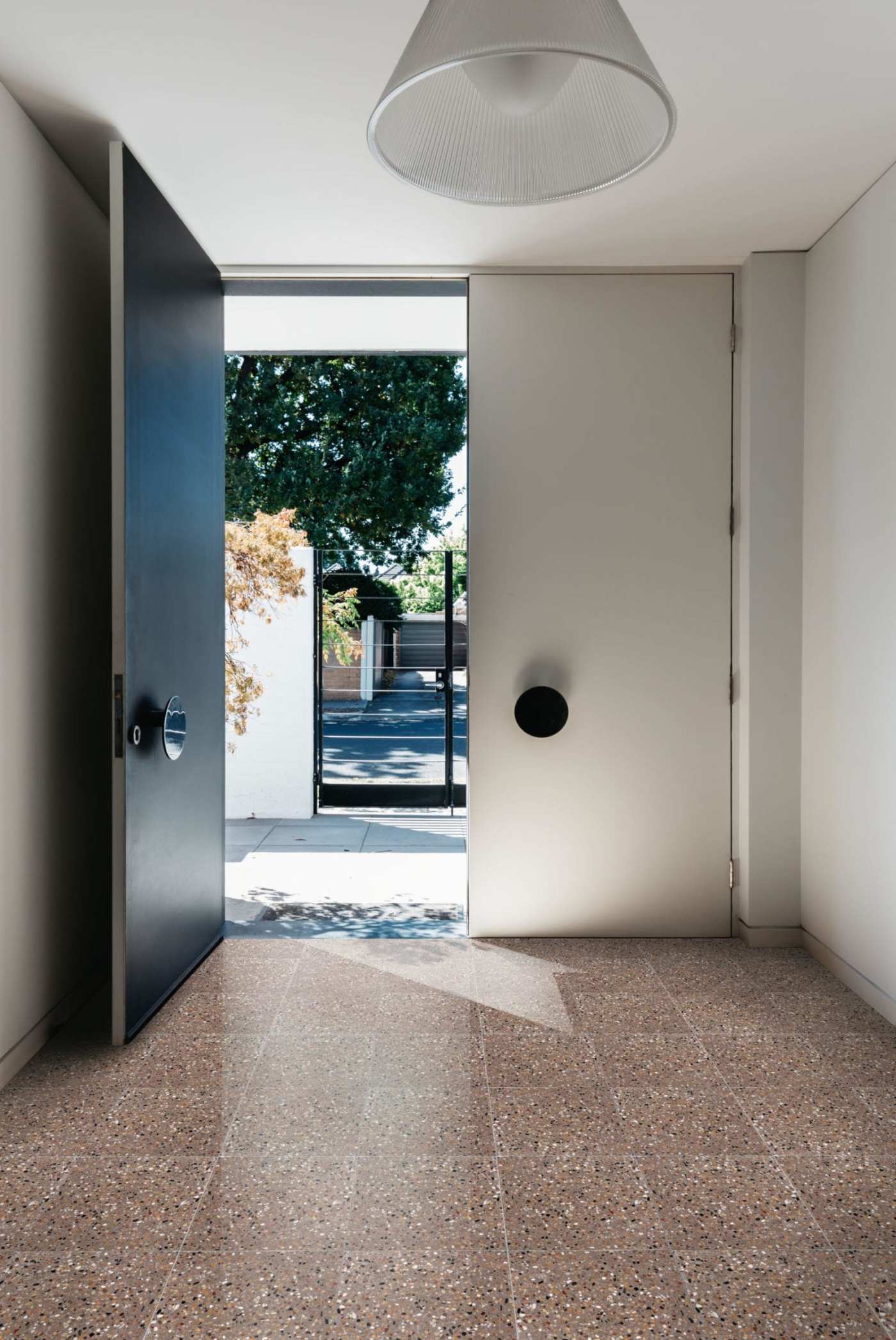 a room with a black door and a brown tile floor.