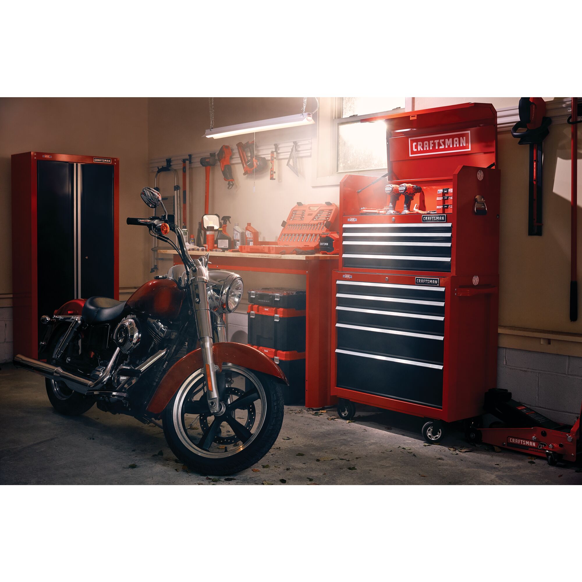 2000 Series 26 inch 5 Drawer Tool Chest with open lid stacked on top of compatible tool cabinet placed in a garage workshop along with other tool storage cabinets equipments and a motorbike.