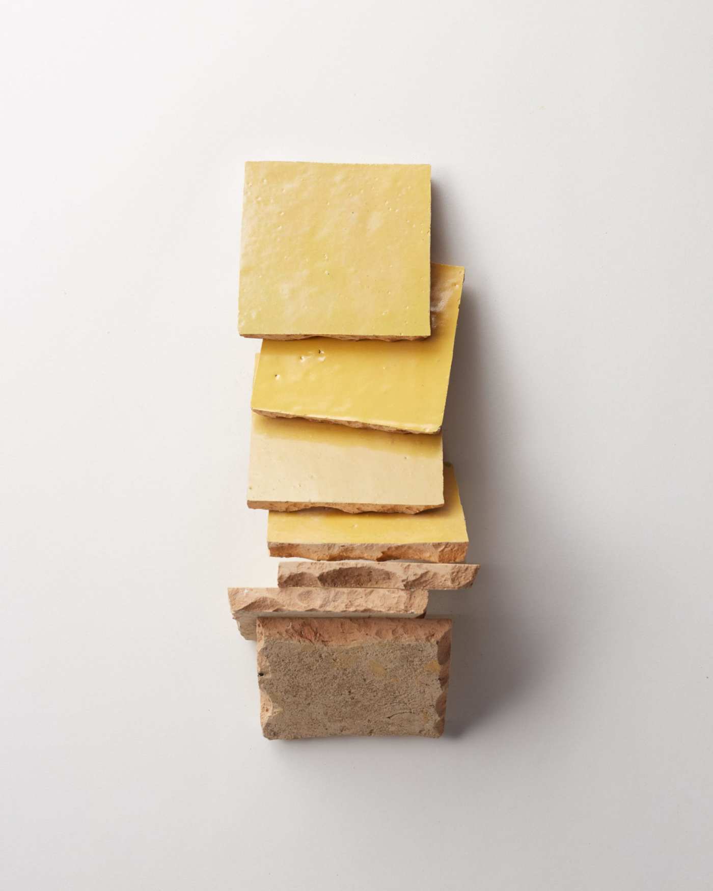 a stack of yellow tiles on a white background.