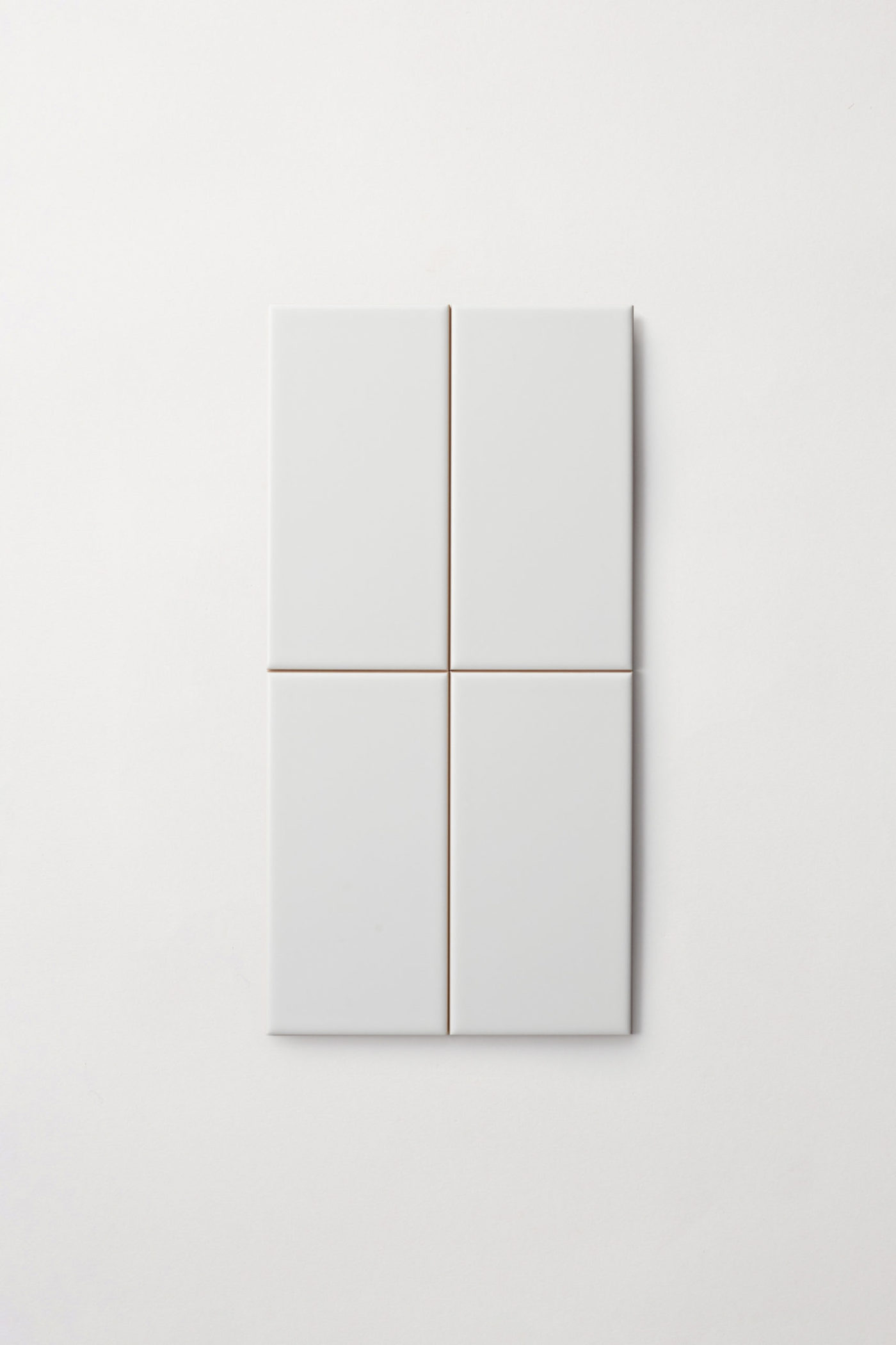 four white rectangle tiles on a white surface.