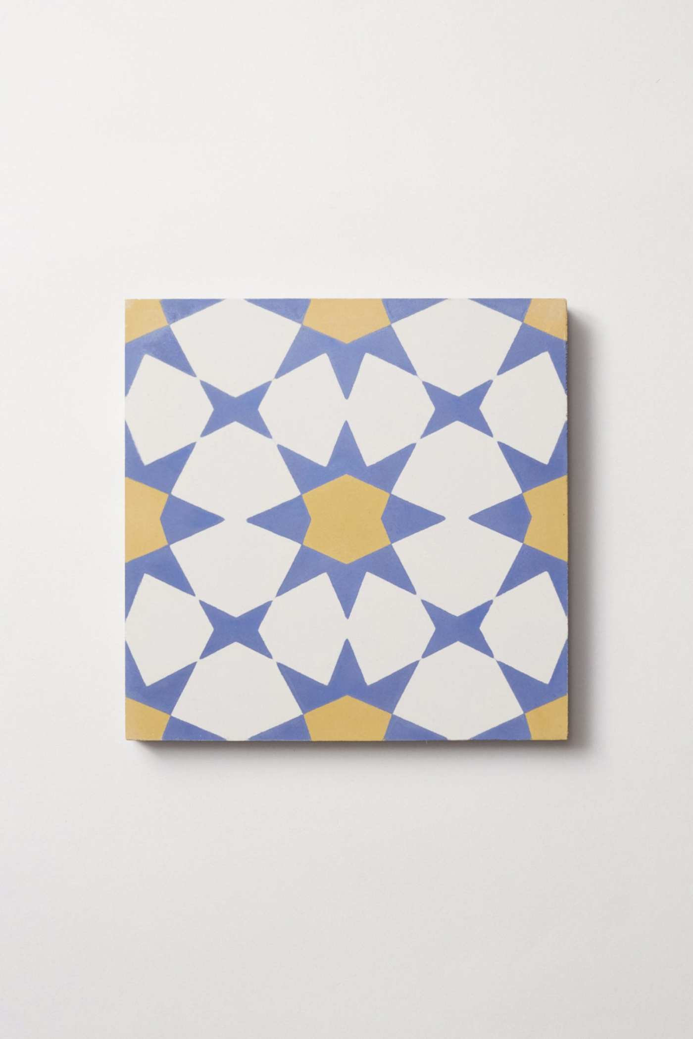 a tile with a white, blue, and yellow geometric pattern on a white background.