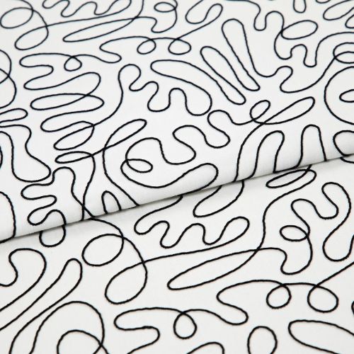 White cotton fabric with continuous black embroidered squiggle pattern, folded once and overlapping; resting flat, showing stitched loops and curves under even studio lighting as a close-up textile sample.