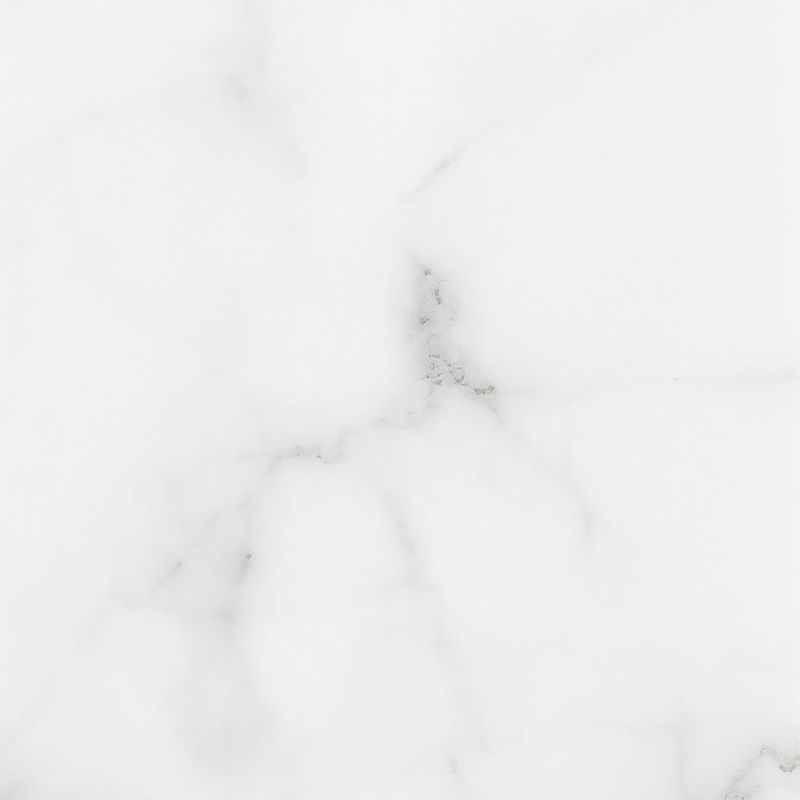 White marble slab displaying faint gray veins and small darker flecks, shown as a close-up square crop under soft, even lighting.