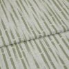 Textured upholstery fabric with vertical olive-green dashed stripes, folded once across the center creating an overlapping seam; close-up view with soft, even lighting and neutral, fabric-only background.