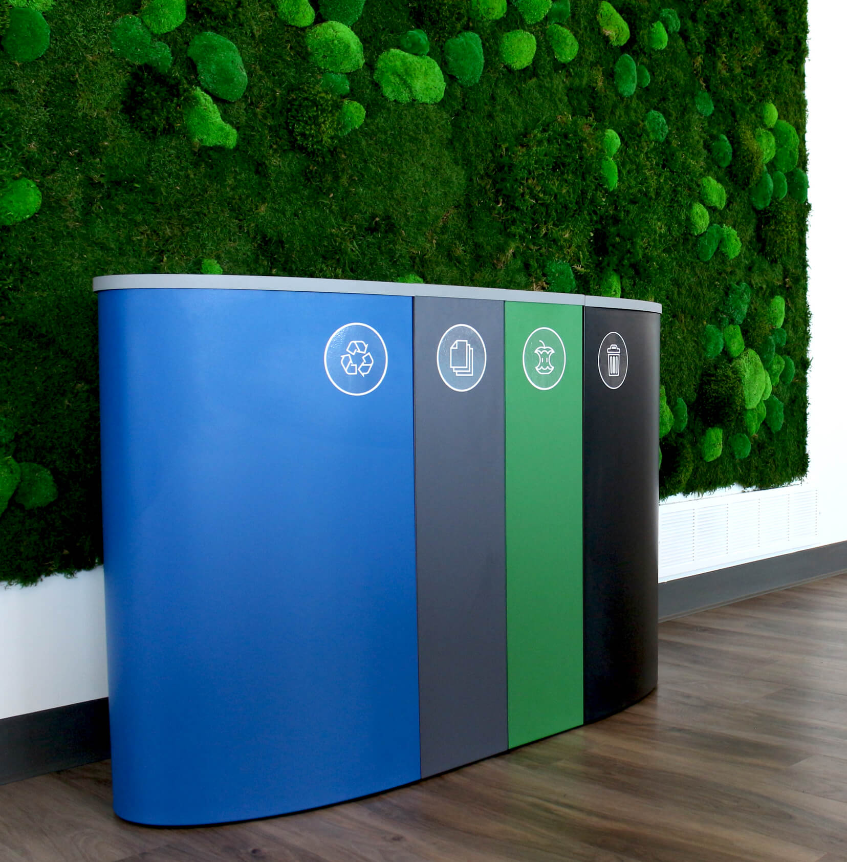 quad waste and recycling container system in a modern office up against a green living wall